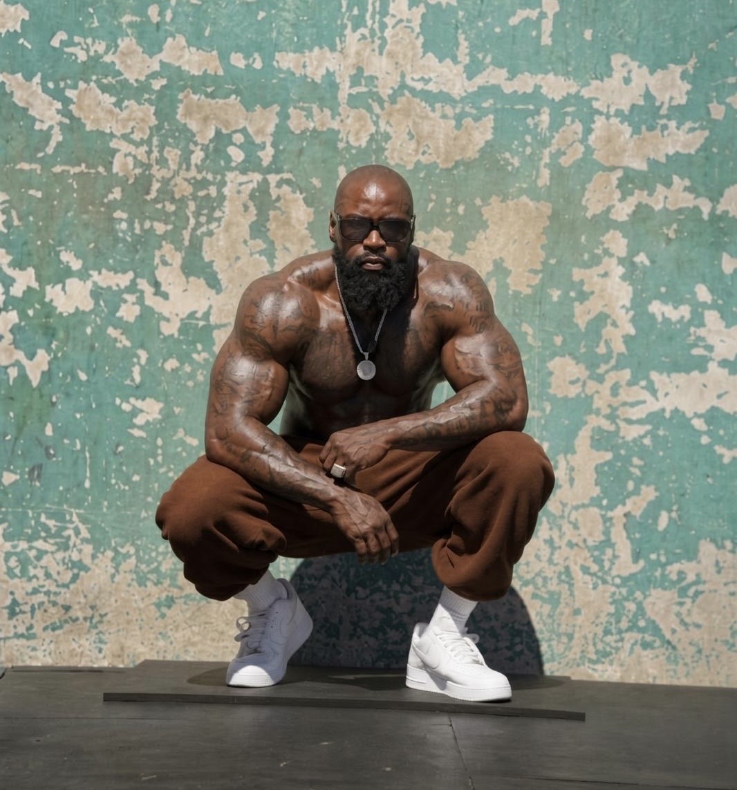 Mike Rashid crouching with his hands together against a textured wall